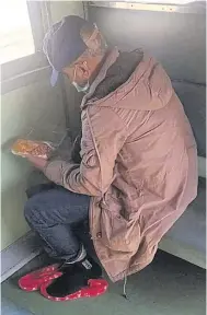  ?? PHOTO POLICE ?? LEFT
Somkid, wearing a mask and cap, is seen holding a meal box on a Surin-Bangkok train in Nakhon Ratchasima yesterday.