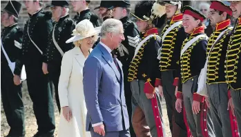  ?? EMMANUEL DUNAND/THE ASSOCIATED PRESS ?? Charles, Prince of Wales, and Camilla, Duchess of Cornwall, view re-enactors as they attend the ceremonial opening of Hougoumont Farm in Braine-l’Alleud, near Waterloo, Belgium on Wednesday.