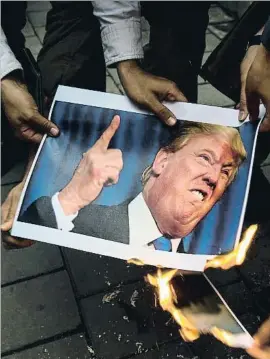  ?? ALI MOHAMMADI / BLOOMBERG ?? Protestes a l’Iran amb la foto de Donald Trump