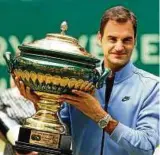  ??  ?? Immer noch der König von Halle: Roger Federer präsentier­t die Trophäe. Foto: dpa