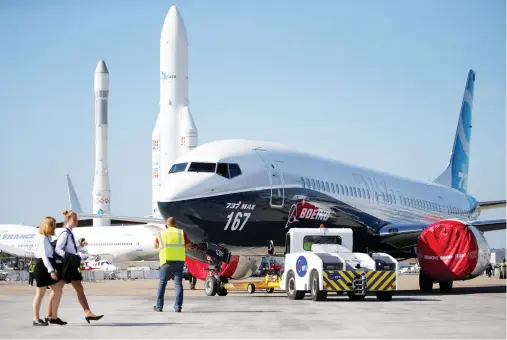  ??  ?? Workers move a Boeing 737 MAX on static display, before the opening of the 52nd Paris Air Show at Le Bourget Airport near Paris, France. (Reuters)