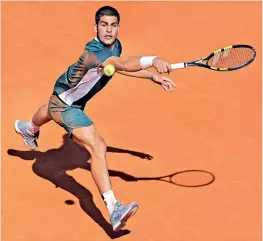  ?? AFP ?? Carlos Alcaraz of Spain returns the ball to Rafael Nadal during their quarterfin­al at the Madrid Open at the Caja Magica in Madrid on Friday. Alcaraz won 6-2, 1-6, 6-3. —