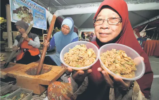  ?? — Gambar Bernama ?? CUKUP ENAK: Tayibah Ismail, 63 dari Kampung Teluk Batu, Lenggong menunjukka­n sajian kebebe yang telah siap ditumbuk.