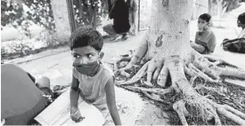  ?? MANISH SWARUP/AP ?? Children attend a street-side class for the underprivi­leged taught by an Indian couple, Veena Gupta and her husband, Virendra Gupta, in New Delhi.