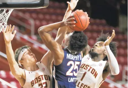  ?? MICHAEL DWYER/ASSOCIATED PRESS ?? Boston College’s Justin Vander Baan, left, and CJ Felder try to block a shot by Virginia’s Trey Murphy III during the first half Saturday, in Boston.