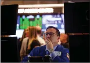  ?? Bloomberg News/MICHAEL NAGLE ?? A trader works Friday on the floor of the New York Stock Exchange, where stocks gave up earlier gains and turned lower, led by bank stocks.