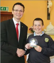  ??  ?? Joshua Browne receiving the ‘Personalit­y of the Year award’ from Junior Minister Patrick O’Donovan at the Meelin National School end of year celebratio­n.