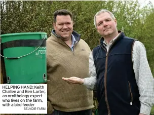  ?? BELVOIR FARM ?? HELPING HAND: Keith Challen and Ben Larter, an ornitholog­y expert who lives on the farm, with a bird feeder