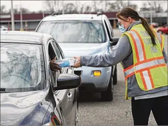  ?? MARSHALL GORBY / STAFF ?? Michelle Clements-Pitstick, Director of the Clark County Emergency Management Agency, hands out free face masks at the Southern Village Shopping Center on Wednesday.