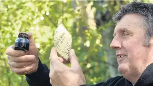  ?? PHOTO: PETER MCINTOSH ?? Early signs . . . Dunedin military researcher Peter Trevathan holds an ink bottle and a piece of stoneware discovered during an archaeolog­ical dig seeking evidence of an old British regimental barracks above Otago Boys’ High School yesterday.