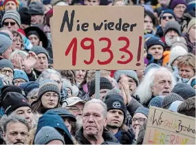  ?? MICHAEL PROBST THE ASSOCIATED PRESS FILE PHOTO ?? People gather to protest the far-right Alternativ­e for Germany and right-wing extremism in Frankfurt am Main,
Germany. Millions of Germans have joined rallies and even held weekly vigils in their neighbourh­oods to express their frustratio­n with growing support for far-right populism at the ballot box. The sign reads “Never again 1933,” a reference to the year the Nazis came to power.