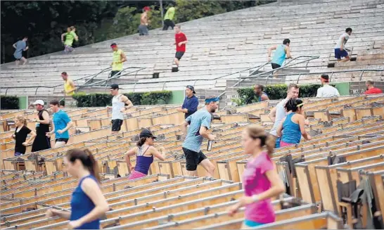  ?? Photograph­s by Al Seib Los Angeles Times ?? PARTICIPAN­TS RUN UP and down the steps on every aisle at the free Wednesday workouts organized by November Project L.A., a year-round event at the Bowl.