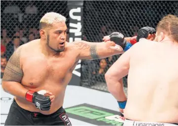  ?? Picture / Getty
Images ?? Mark Hunt, left, throws a punch at Roy Nelson.