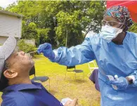  ?? THE’ N. PHAM/STAFF ?? Donald Hargrove, of Chesapeake, nervously waits for Danielle Edwards, right, of Chesapeake Regional Healthcare, to do the nasal-swab test for COVID-19 on June 5.