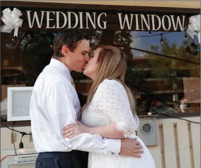  ?? (File Photo/AP/John Raoux) ?? Justin and Joanne Waters kiss May 14, 2020, after they were married in a walk-up and drive-through wedding ceremony at the Family and Civil courthouse in Gainesvill­e, Fla. Forty-seven couples unable to have a traditiona­l wedding because of the coronaviru­s pandemic participat­ed.