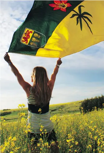  ??  ?? Saskatchew­anderer Ashlyn George holds a Saskatchew­an flag in a canola field. BELOW, she takes in the Eiffel Tower Park in Montmartre, Sask.