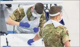  ?? Peter Byrne / Associated Press ?? Soldiers carry out mass coronaviru­s testing, set up at a marketplac­e in Liverpool, England, during the four-week national lockdown to curb the spread of coronaviru­s in England, on Wednesday.