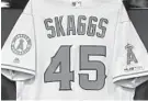  ?? TONY GUTIERREZ/AP ?? The jersey of the late Tyler Skaggs hangs on the wall during a news conference in Texas.