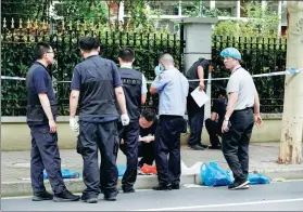  ?? GAO ERQIANG / CHINA DAILY ?? Police examine the site of a knife attack that occurred on Thursday morning in downtown Shanghai leaving two boys dead and another boy and a parent wounded.