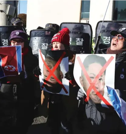  ??  ?? South Koreans hold pictures of North Korean leader Kim Jong Un to protest the arrival of North Korean athletes. | LEE JIN- MAN/ AP