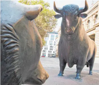  ?? FOTO: DPA ?? Börsenplat­z Frankfurt: Bulle und Bär sind Symbole für die Auf- und Abwärtsbew­egung an den Börsen.