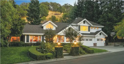  ?? Photos by Open Homes Photograph­y ?? Above: Manicured hedges and rose bushes lend curb appeal to the Lafayette home at 3455 Stage Coach Drive. The six-bedroom home is available for $2.875 million. Below left: The great room features a cathedral ceiling, a pair of skylights and a...