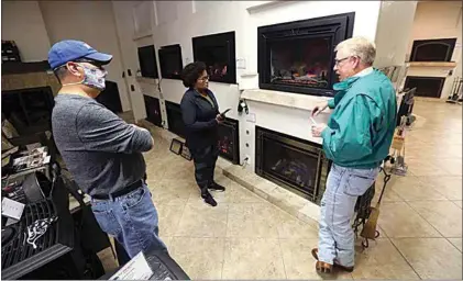  ?? THE CALIFORNIA­N ?? In this 2021 photo, Phil Thompson and Kimberley Ellis shop for a fireplace insert for their home with the help of manager Gary Flanagan at Econo Air on Union Avenue in Bakersfiel­d.