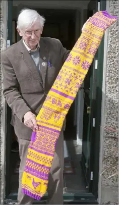  ??  ?? Former councillor Sean Doyle with the purple and gold scarf he knitted while cocooning at his home