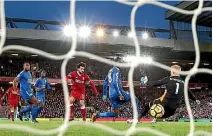  ??  ?? Mohamed Salah scores the first Liverpool goal, slipping the ball past Leicester City keeper Kasper Schmeichel.