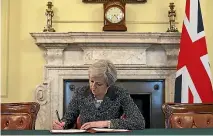  ?? PHOTO: REUTERS ?? British Prime Minister Theresa May in the cabinet office signs the official letter to European Council President Donald Tusk invoking Article 50 and the UK’S intention to leave the EU.
