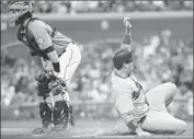  ?? Thearon W. Henderson
Getty Images ?? DODGERS’ A.J. ELLIS scores from first on a Juan Uribe triple as Giants catcher Buster Posey stands by.