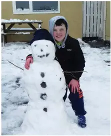  ??  ?? Keelan Kelliher pictured with his new snowman friend in Castlemain­e on Friday afternoon.