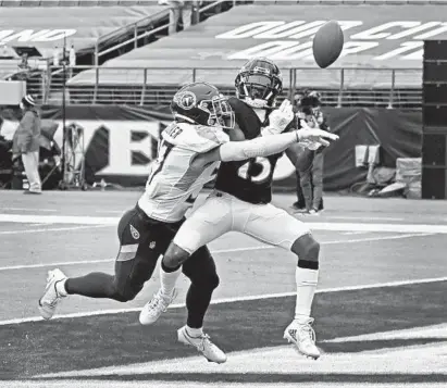  ?? KENNETH K. LAM /BALTIMORE SUN ?? Titans safety Amani Hooker, left, breaks up a pass in the end zone intended for Ravens wide receiver Marquise Brown in the second quarter Sunday.