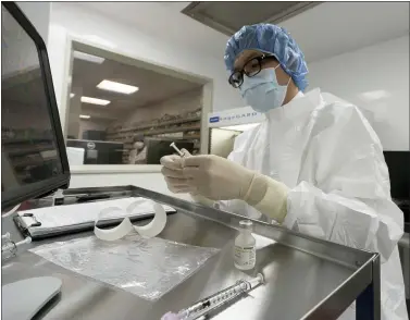  ?? MARK LENNIHAN - THE ASSOCIATED PRESS ?? A pharmacist labels syringes in a clean room where doses of COVID-19 vaccines will be handled, Wednesday, Dec. 9, 2020, at Mount Sinai Queens hospital in New York. The hospital expects to receive doses once a vaccine gets the emergency green light by U.S. regulators.