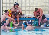  ??  ?? Right, Swimmers tape fins and adjust their gloves as they prepare to hit the water.