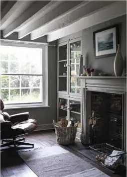  ??  ?? THIS PAGE The woodburner in the double-sided fireplace serves both the library (above) and the living room (left) OPPOSITE A Lloyd Loom chair with a table by Hein Bonger and a lamp from a charity shop make a cosy reading corner