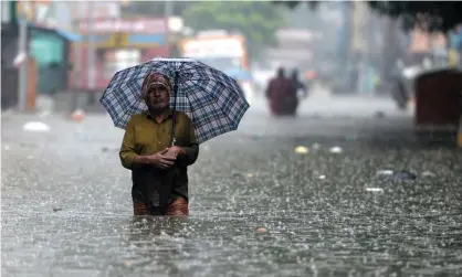  ?? ?? A man wades through a flooded street after heavy monsoon rains in Chennai, India, 8 November. Photograph: Arun Sankar/AFP/Getty Images