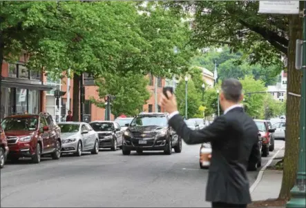  ?? FILE PHOTO ?? Troy restaurate­ur and ride-hailing advocate Vic Christophe­r holds up his phone outside of his restaurant Little Peck’s in downtown Troy on the first day of ride-hailing in the Capital Region last year.