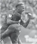  ??  ?? Brazil's Neymar, top, celebrates with teammate Douglas Costa after scoring his side's second goal against Costa Rica on Friday in St. Petersburg, Russia.