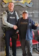  ?? Kelowna RCMP ?? Const. Mike Della-Paolera returns a 1979 Wayne Gretzky hockey card to Ian Moore.