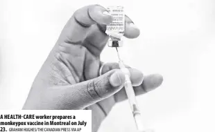  ?? GRAHAM HUGHES/THE CANADIAN PRESS VIA AP ?? A HEALTH-CARE worker prepares a monkeypox vaccine in Montreal on July 23.