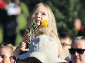  ?? LINDSEY PARNABY / AFP / GETTY IMAGES ?? A young girl watches from her father’s shoulders during a vigil in Royton, England, to commemorat­e the victims of last week’s suicide bombing at Manchester Arena.