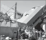  ?? AP/ GLADYS TSAI ?? Rescue workers search for survivors Monday in the wreckage of a collapsed building in Tainan, Taiwan.