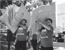  ?? Hyoung Chang, The Denver Post ?? Volunteers Emad Ismael, left, and Jeffery Alameda move empty cardboard boxes used for supplies Saturday.