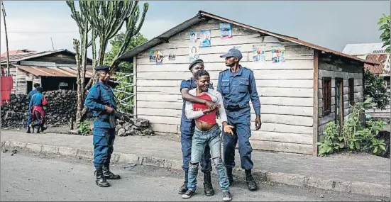  ?? PATRICK MEINHARDT / AFP ?? Agentes de la policía deteniendo a un joven durante las protestas contra el retraso parcial de las elecciones, ayer en la provincia de Kivu Norte