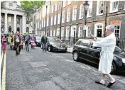  ??  ?? Former Tory party treasurer Lord Fraser emerged from his home in Westminste­r to confront the Extinction Rebellion protesters. At one point, below, he appeared to raise his fists to the crowd