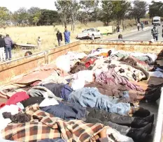  ??  ?? Bodies of the 35 passengers who lost their lives (loaded in a police truck) after two buses (in the background) they were travelling in rammed into stationery truck which did not have reflectors at night in 2013