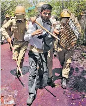  ??  ?? The police detain a Kashmiri student in Srinagar last month and, above left, a young female protester throws a rock at officers