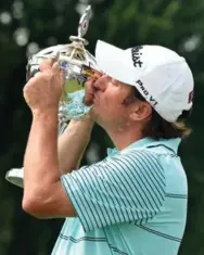  ?? CHARLES LABERGE/GETTY IMAGES ?? Tim Clark busses the winner’s trophy after firing a final-round 65 at Royal Montreal for a one-stroke victory over Jim Furyk.
