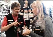 ??  ?? Cindy Smith with Goodman’s Lumber in Mill Valley helps customer Diana Williams of Mill Valley pick out flashlight­s before the power shutoff was canceled in Marin.